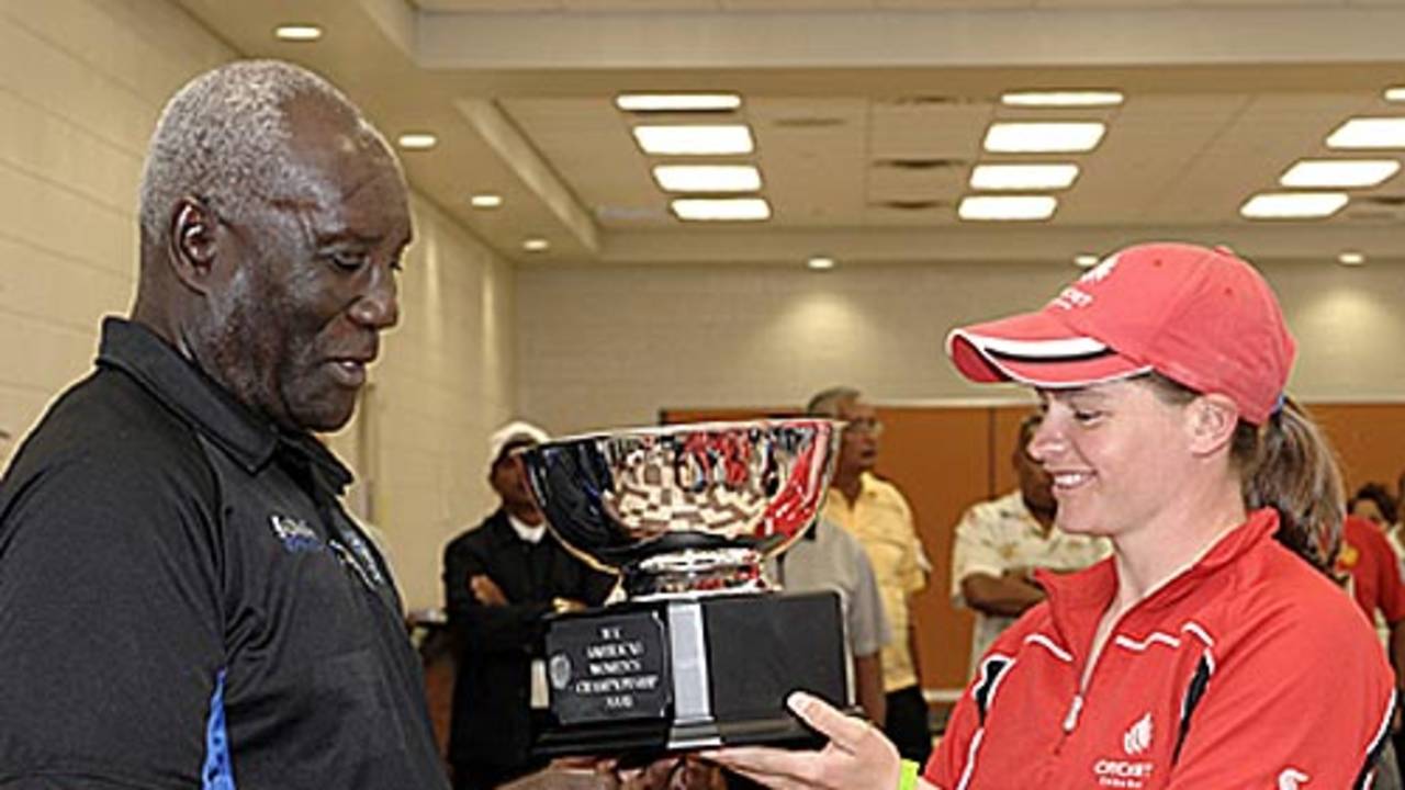 Event co-ordinator Mr.Selwyn Caesar hands the Americas Women's Championship trophy to Canadian captain, Joanna White.
