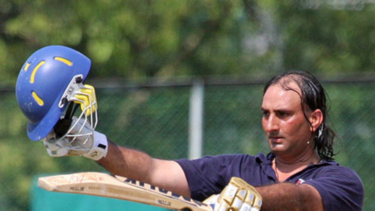 Zaheer Ashiq raises the bat after reaching his half-century