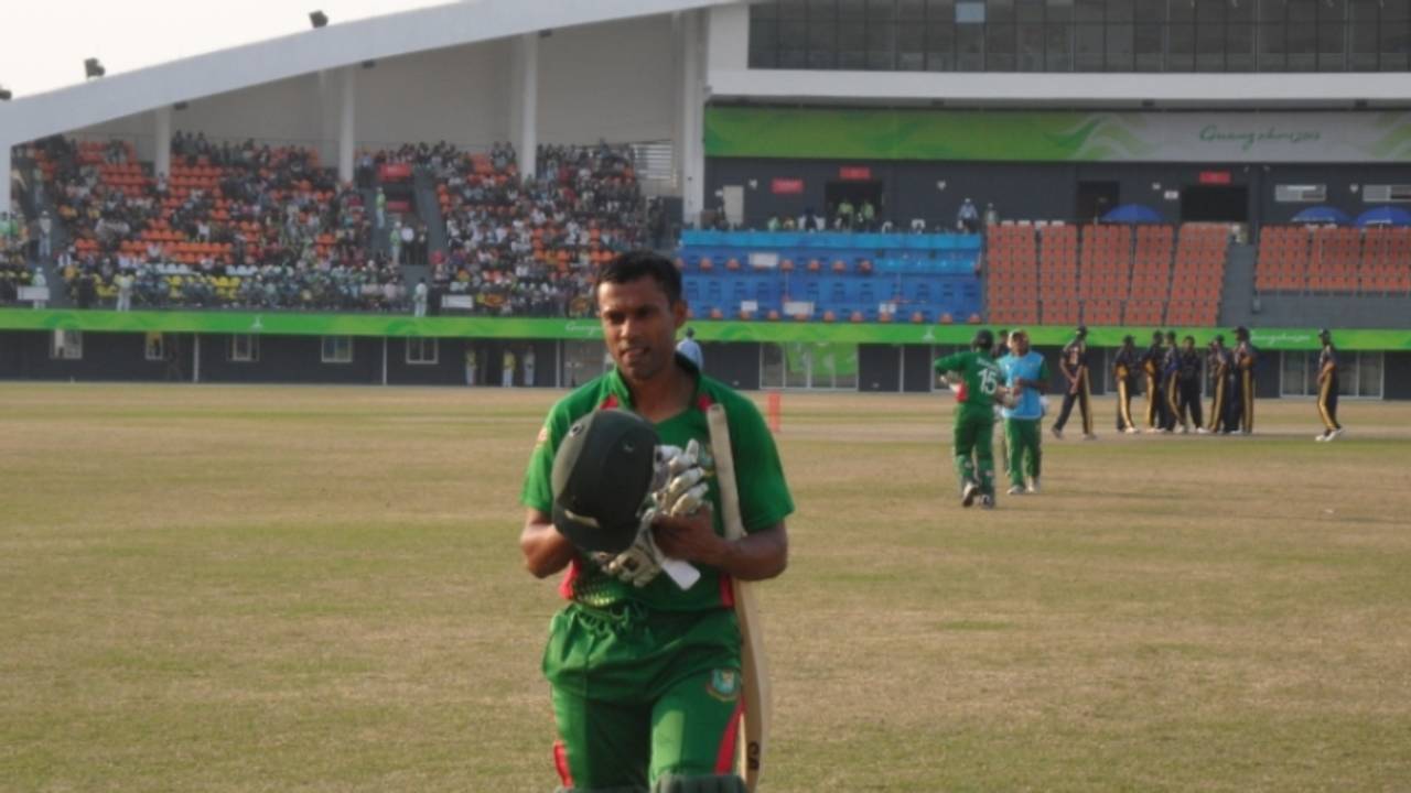 Faisal Hossain, Bangladesh's top scorer, leaves the field after being dismissed for 33