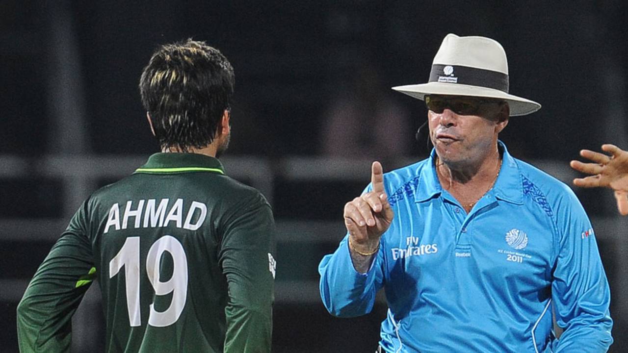 Umpire Daryl Harper warns Ahmed Shehzad not to talk too much to the batsman