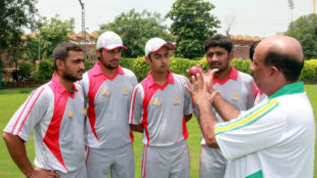 Tauseef Ahmed, the PCB's regional head coach for Hyderabad, illustrates a point while talking to young cricketers