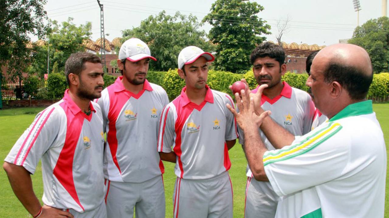 Tauseef Ahmed, the PCB's regional head coach for Hyderabad, illustrates a point while talking to young cricketers