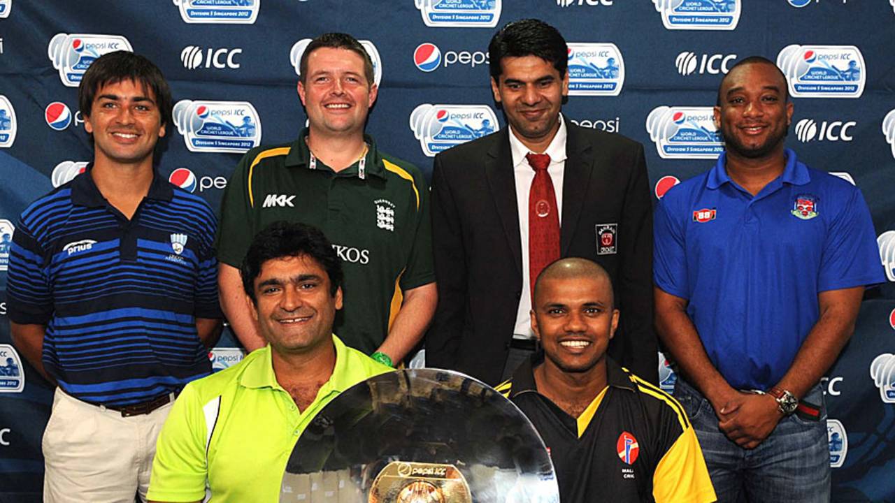 Captains pose with the ICC World Cricket League Division 5 trophy