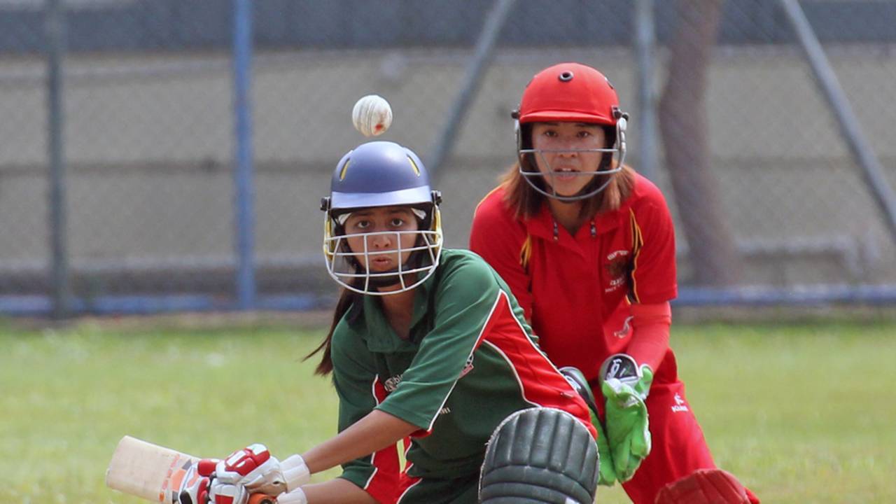 Priya Jain (KCC Maidens) and Natural Yip (HKCC Cavaliers) keep their eyes on the ball during their Women's T20 Cup match at Mission Road on 14th October 2012