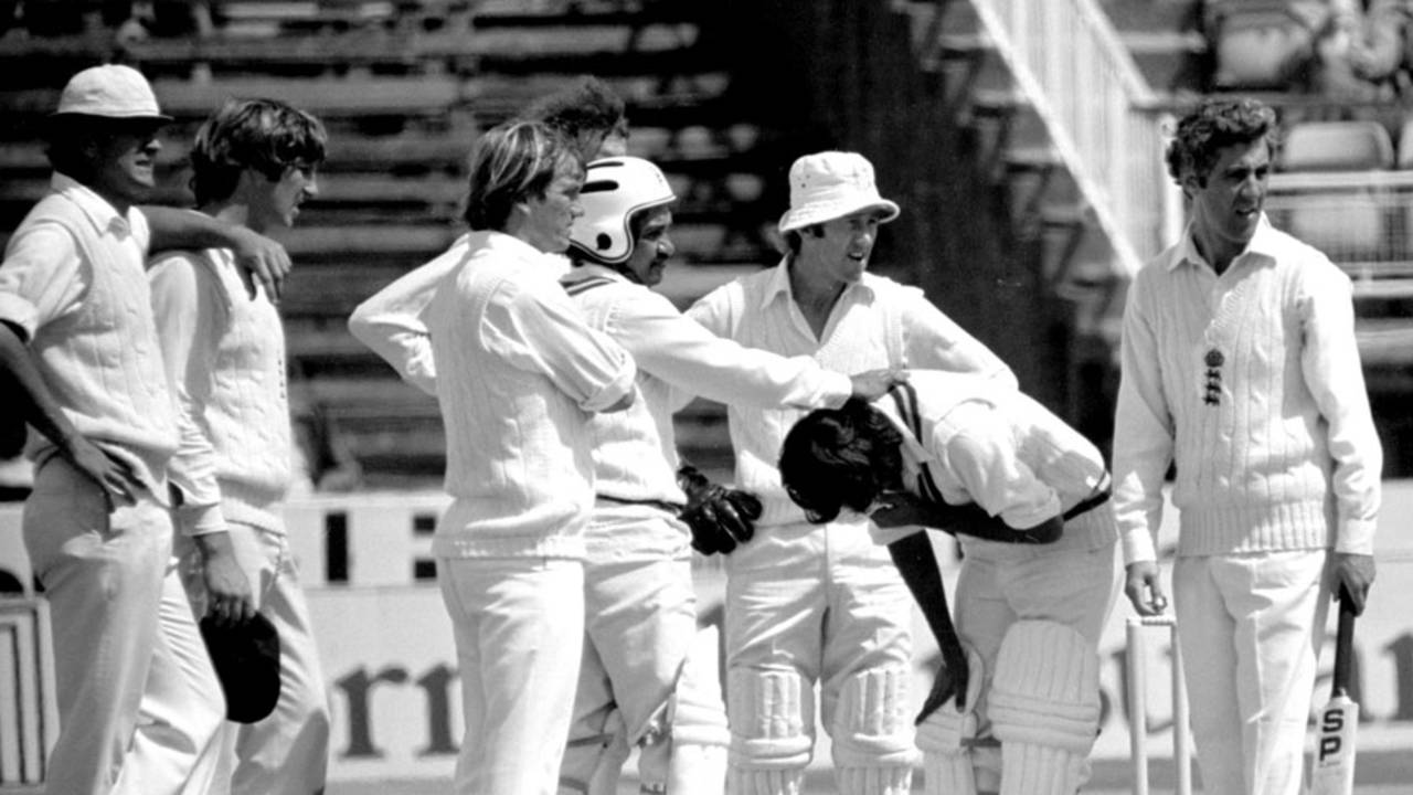 England players gather round Iqbal Qasim after he was struck by a Bob Willis bouncer