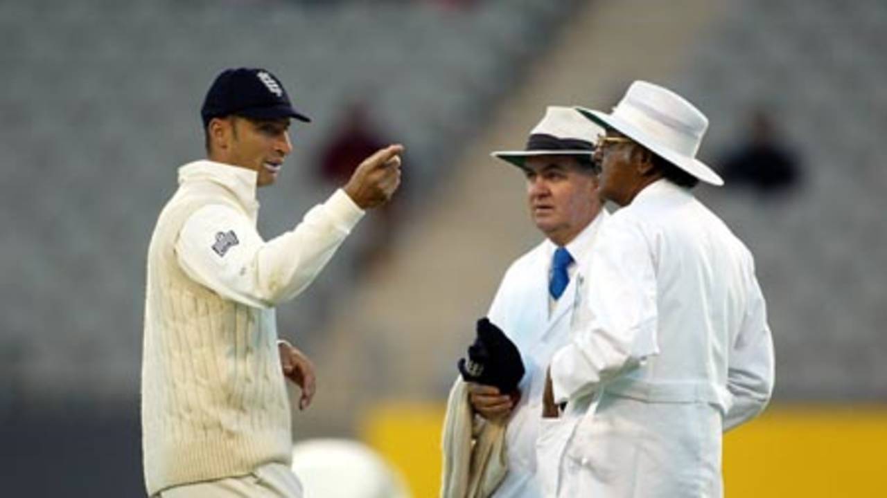 England captain Nasser Hussain (left) discusses the light conditions with umpires Doug Cowie (centre) and Srinivas Venkataraghavan from India. The umpires allowed play to continue under artificial lighting until the scheduled minimum number of overs were bowled. 3rd Test: New Zealand v England at Eden Park, Auckland, 30 March-3 April 2002 (2 April 2002).