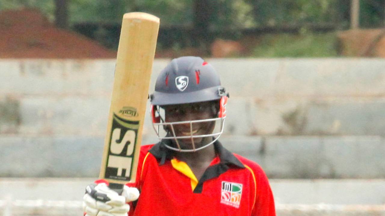 Clive Chitumba raises his bat after hitting fifty 
