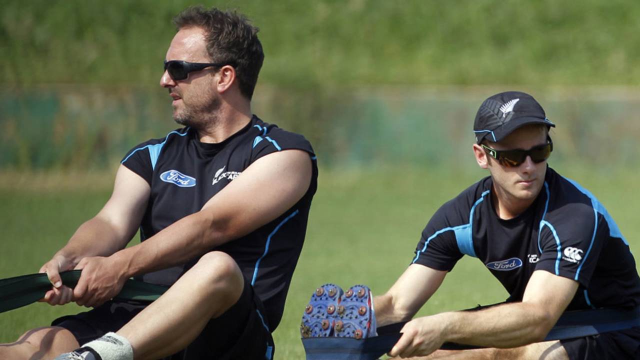 Kane Williamson and Mark Gillespie stretch during training