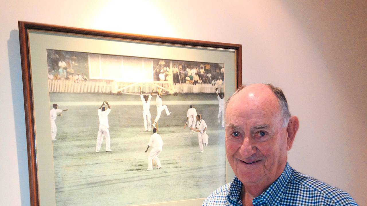 Ian Meckiff poses next to the picture of the tied Test at home, Melbourne