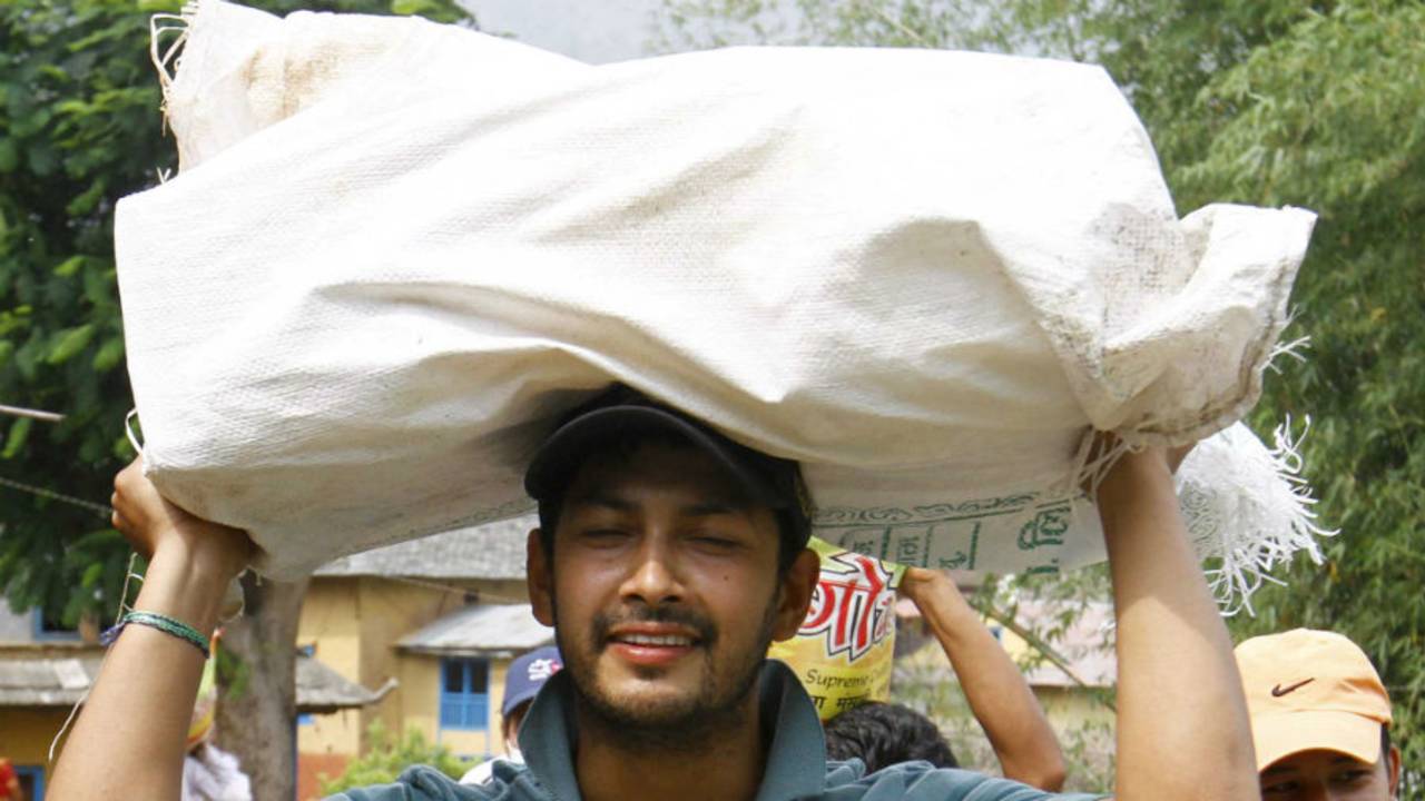 Subash Khakurel, wicket keeper batsman of the Nepal national cricket team carrying relief material to earthquake victims at Baseshwor VDC in Sindhuli on May 7 2015.