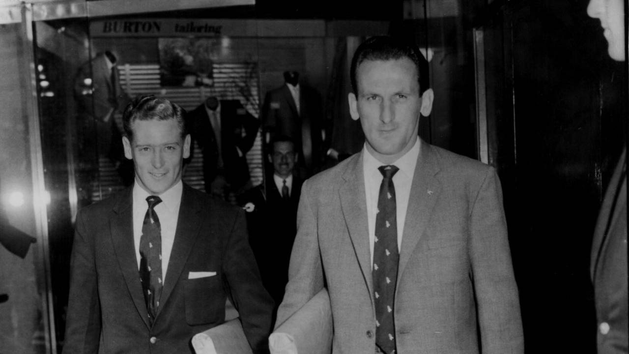 Jackie McGlew and Sid O'Linn walk out of a tailoring store in their new suits