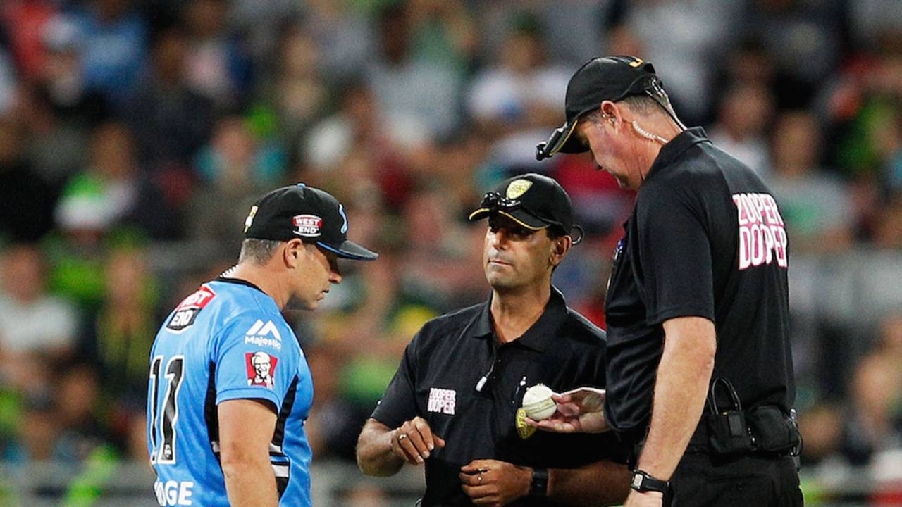 Umpires Greg Davidson and Gerard Abood inspect the ball with Brad Hodge
