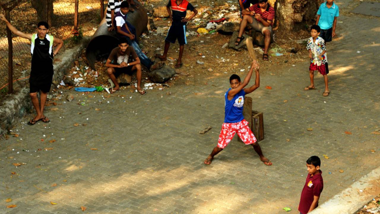 Boys play cricket on the street in Malabar Hill, Mumbai, November 26, 2012