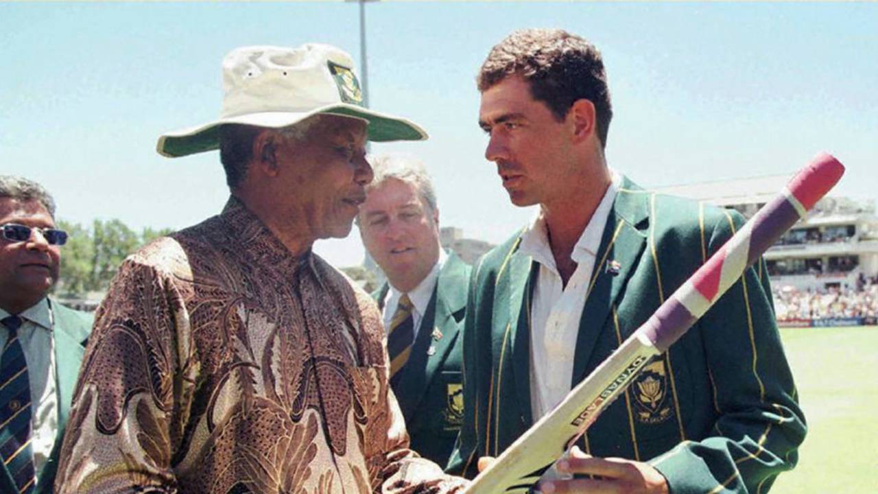 South Africa's president Nelson Mandela receives a cricket bat from the national team's captain, Hansie Cronje, South Africa v India, second Test, third day, Cape Town, January 4, 1997 