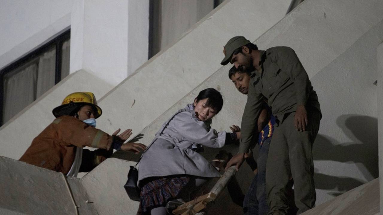 A guest at Regent Plaza Hotel is helped to safety after a fire broke out at the hotel, Karachi, December 5, 2016