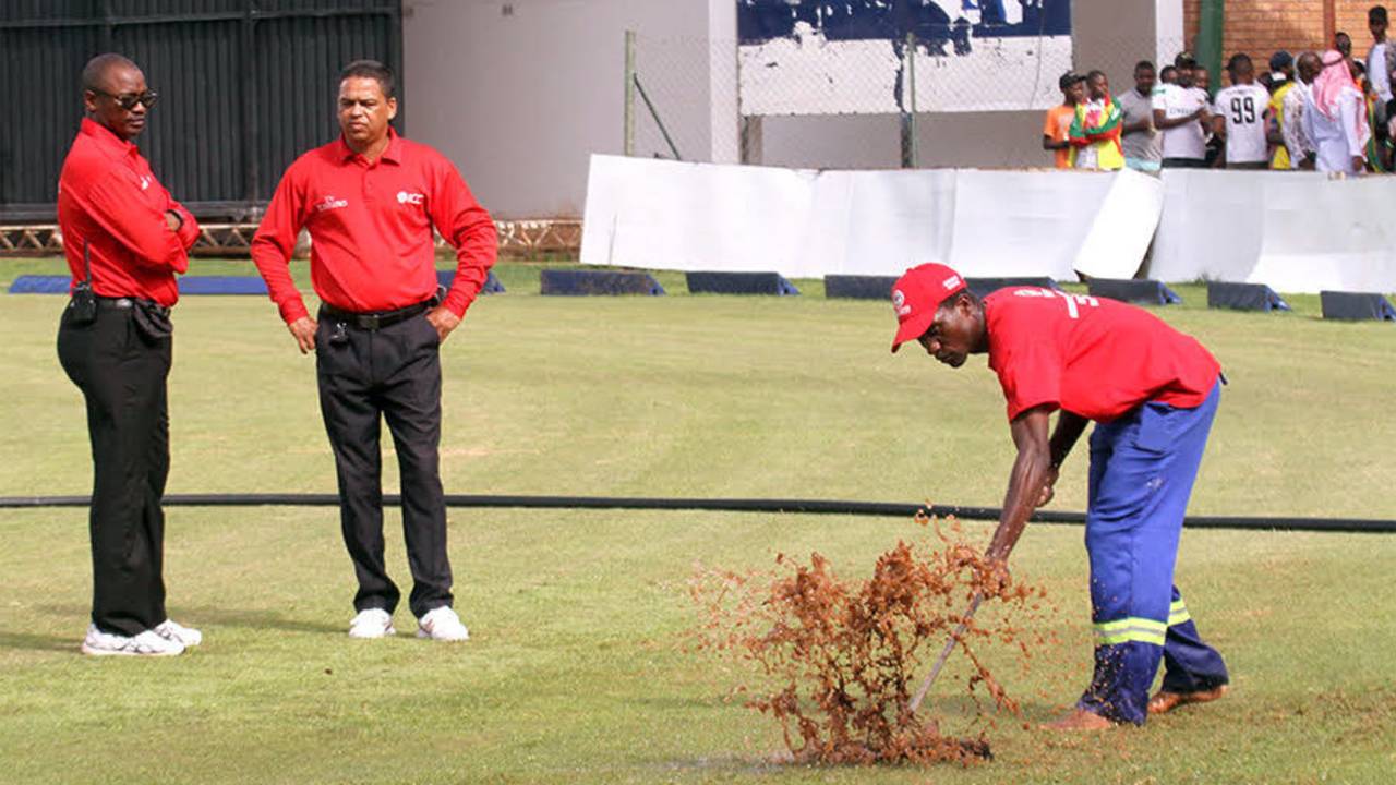 Umpires Jeremiah Matibiri and Shaun George watch ground staff attempt to dry the outfield, Zimbabwe v Afghanistan, 5th ODI, Harare, February 26, 2017