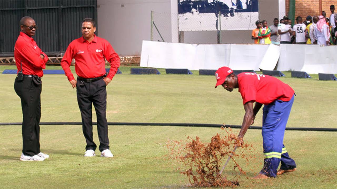 Umpires Jeremiah Matibiri and Shaun George watch ground staff attempt to dry the outfield, Zimbabwe v Afghanistan, 5th ODI, Harare, February 26, 2017