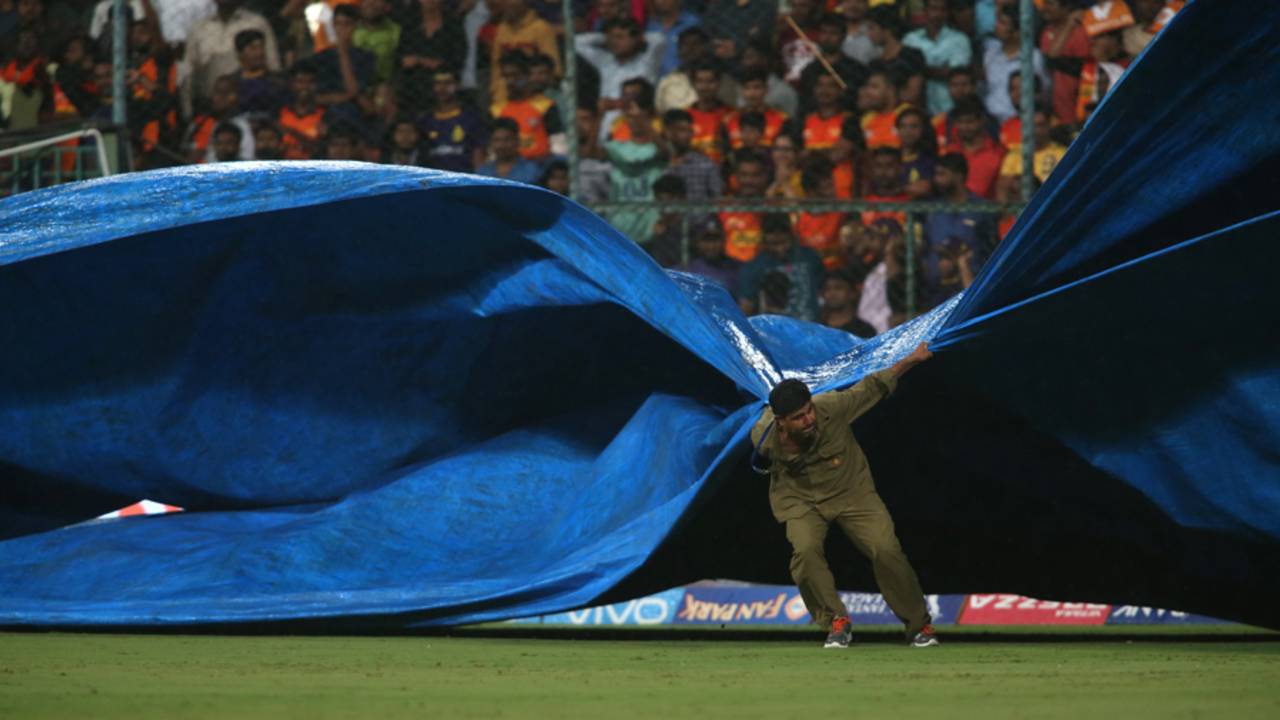 A groundsman at the M Chinnaswamy Stadium brings the covers on as rain started to fall , Sunrisers Hyderabad v Kolkata Knight Riders, Eliminator, IPL 2017, Bangalore, May 17, 2017