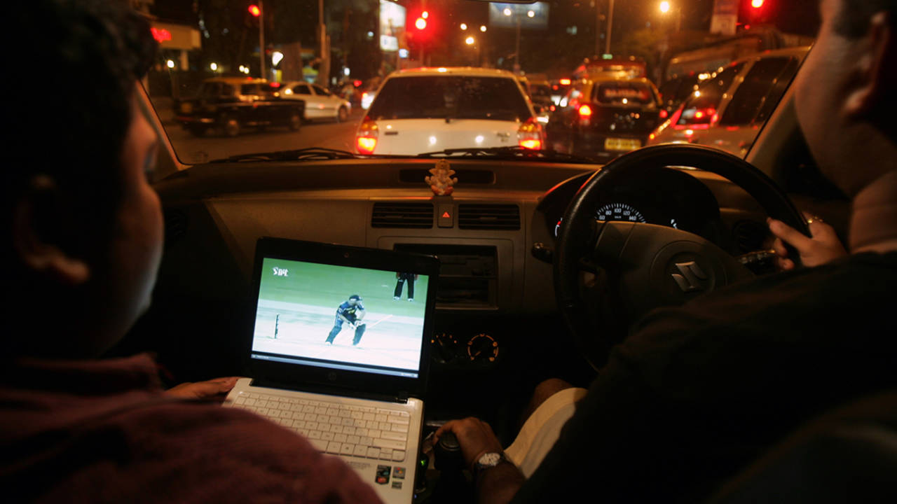 A man watches an IPL game on his laptop while waiting in a car in traffic, Mumbai, April 19, 2010