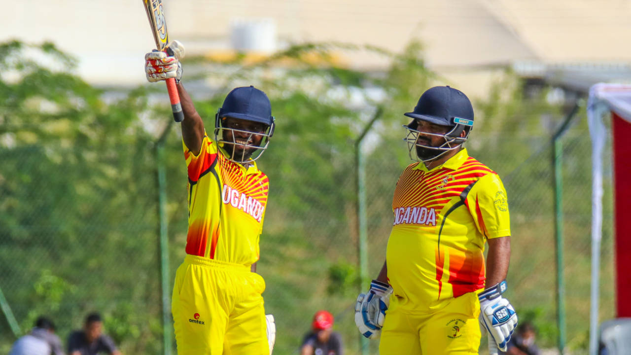 Arnold Otwani grins and raises his bat high after raising a sharp half-century, Denmark v Uganda, ICC World Cricket League Division Three, Al Amerat, November 9, 2018