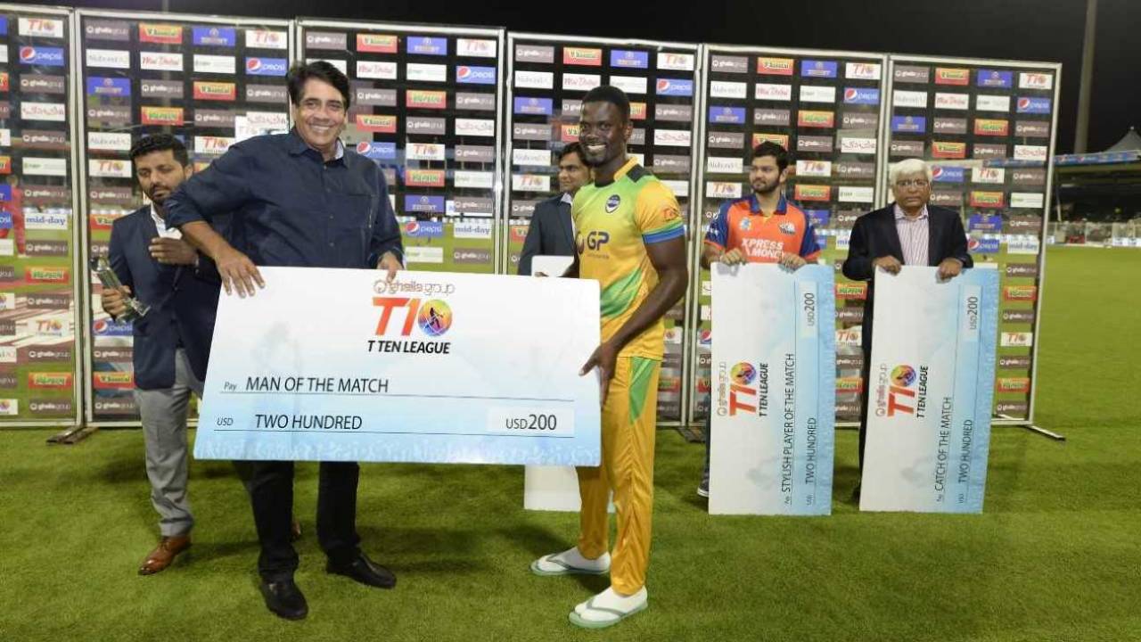 Arvinder Singh, the T10 League CEO, hands over the Player of the Match cheque to Andre Fletcher