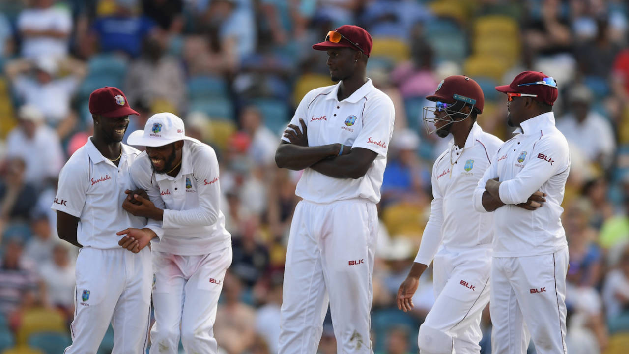 Roston Chase and Kemar Roach share a joke as captain Jason Holder awaits the umpires decision, Day Four, First Test match, England v West Indies, Kensington Oval, Bridgetown, Barbados, January 26, 2019.