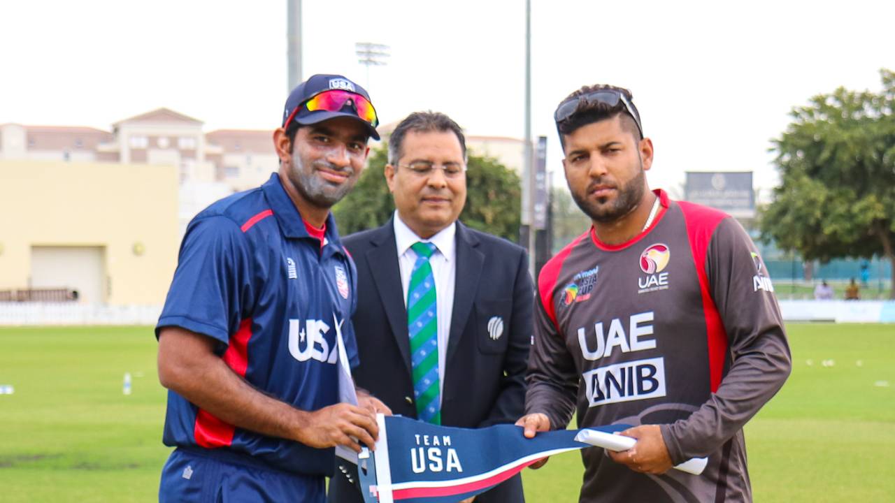USA captain Saurabh Netravalkar presents a Team USA flag at the toss for USA's maiden T20I