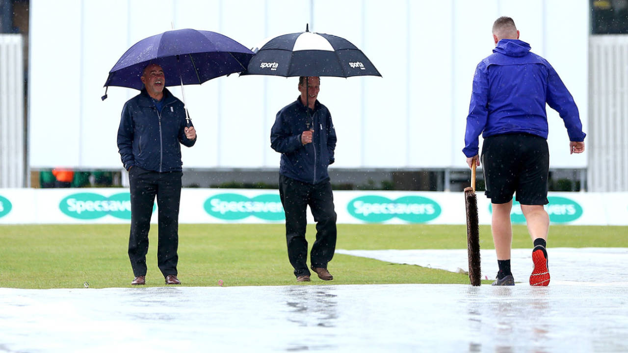 The umpires inspect the field as rain delays play on day one, Surrey v Yorkshire, County Championship Division One, Woodbridge Road, Guildford, June 10, 2019