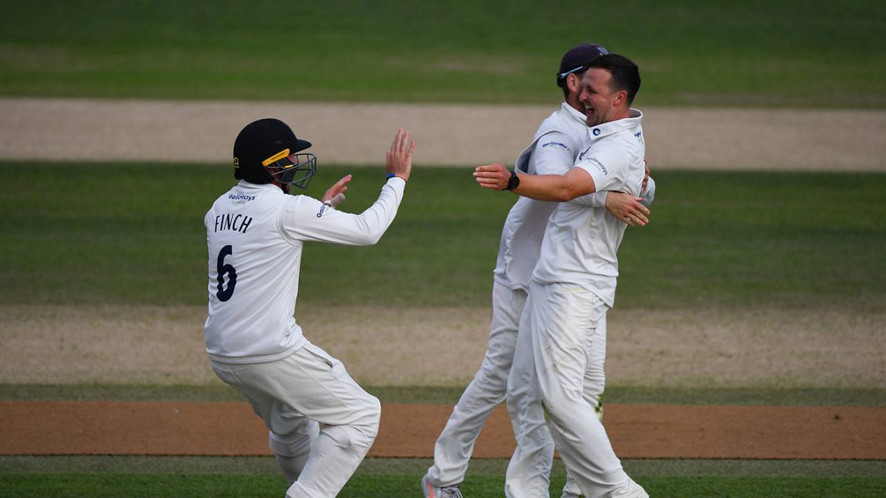 Elliot Hooper celebrates a maiden first-class wicket