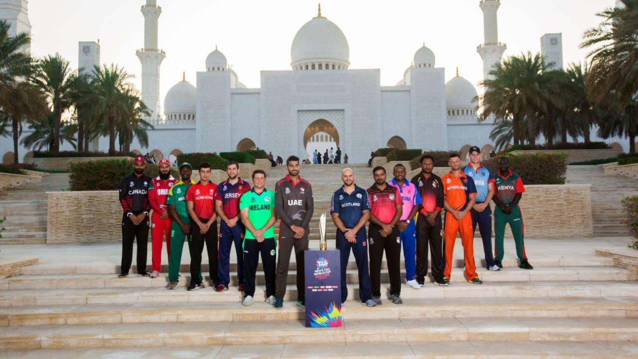 The 14 captains with the ICC men's T20 World Cup Qualifier trophy