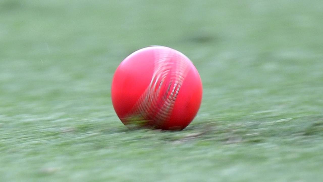 The pink ball rolls across the outfield