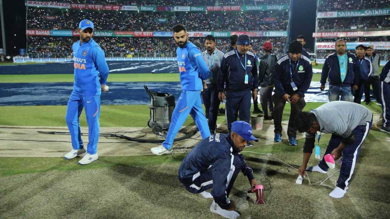 Shikhar Dhawan and Virat Kohli stand pitch side as the groundstaff works on drying the pitch after rain, India v Sri Lanka, 1st T20I, Guwahati, January 5, 2020
