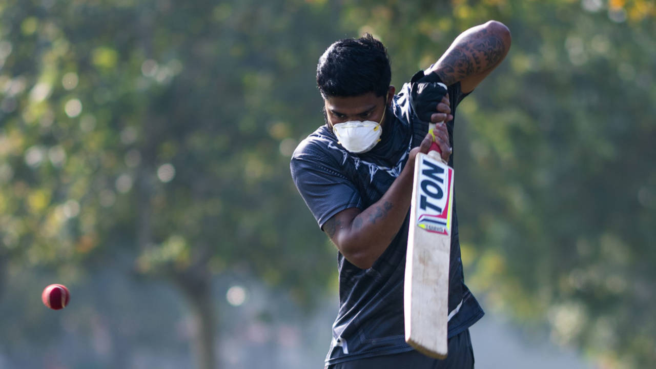 A youth plays cricket in a mask to combat COVID-19, New Delhi, March 18, 2020