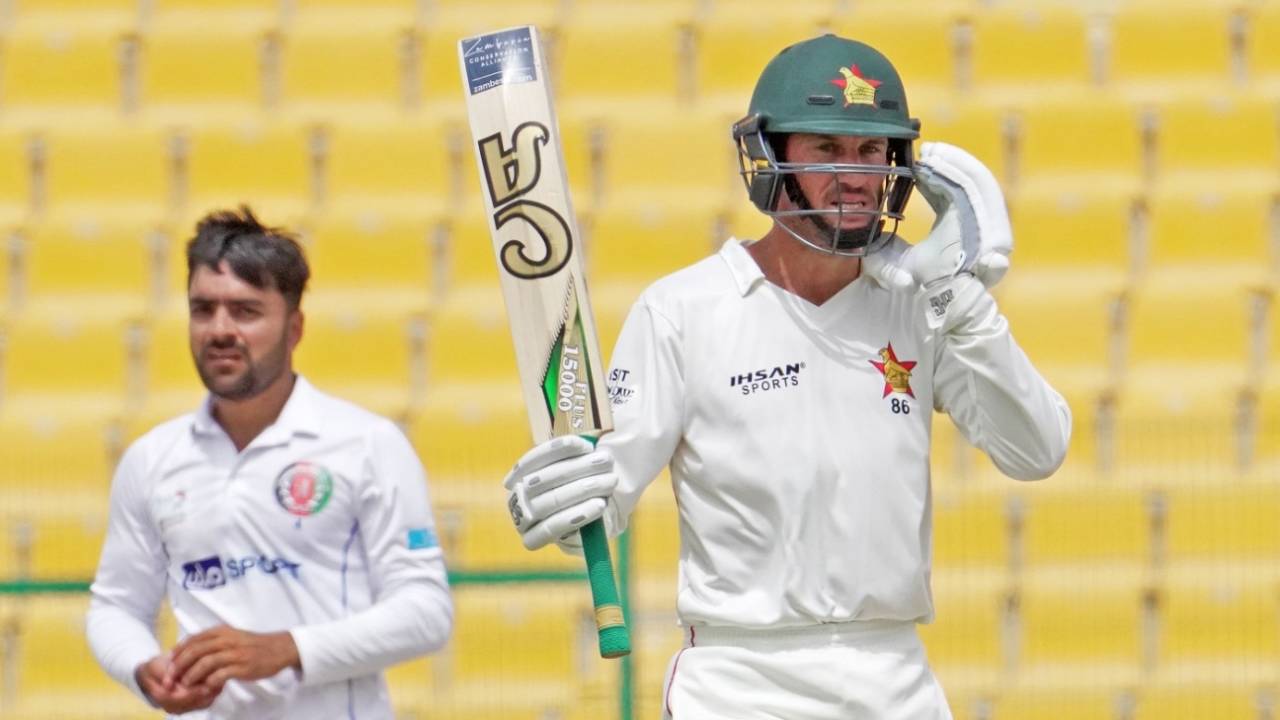 Sean Williams raises his bat after getting to 150 as Rashid Khan looks on, Afghanistan vs Zimbabwe, 2nd Test, Abu Dhabi, 5th day, March 14, 2021 