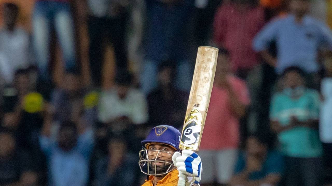 R Sanjay Yadav raises his bat after reaching a half-century