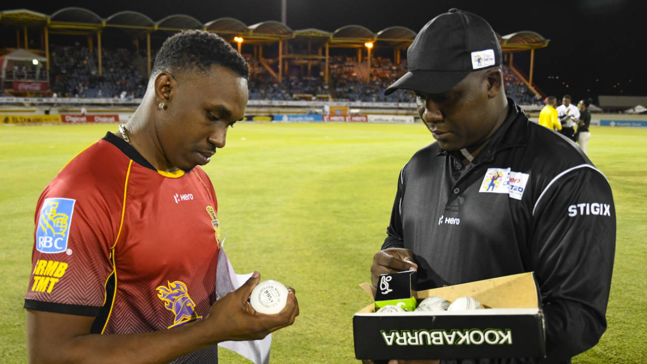 Dwayne Bravo chooses a ball from reserve umpire Myron James, Gros Islet, August 5, 2017