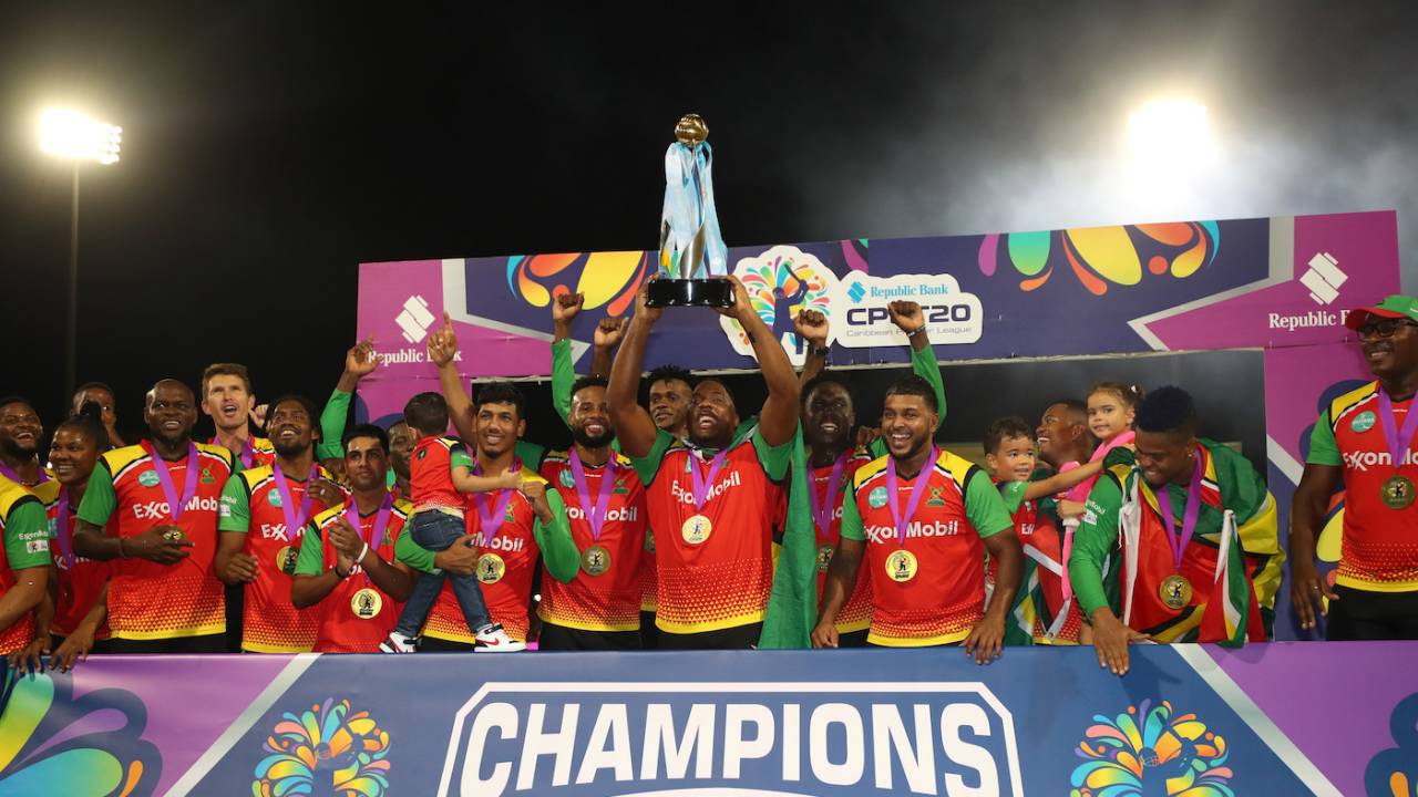 Guyana Amazon Warriors players gather around Odean Smith to celebrate their win