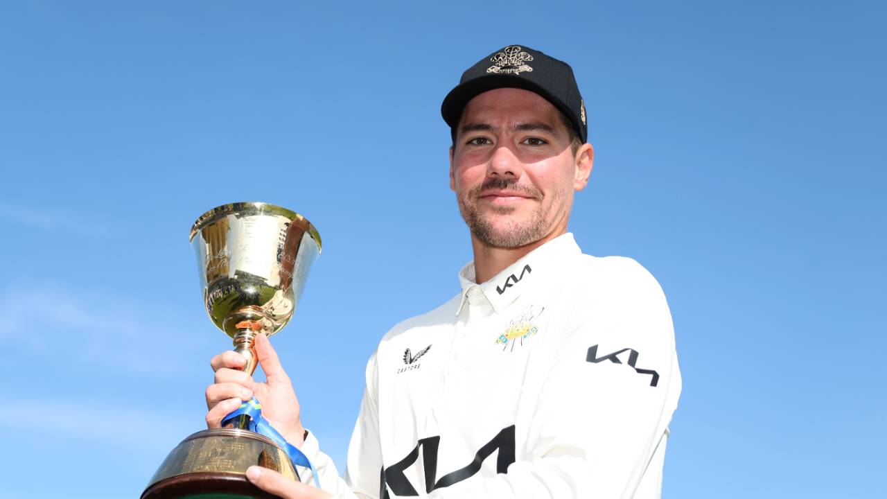 Rory Burns poses with the County Championship trophy after captaining Surrey to back-to-back titles