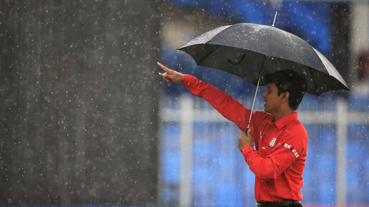 Umpire Sharfuddoula shelters under an umbrella, Afghanistan v Nepal, ICC World Twenty20 Qualifier, Group B, Sharjah, November 22, 2013
