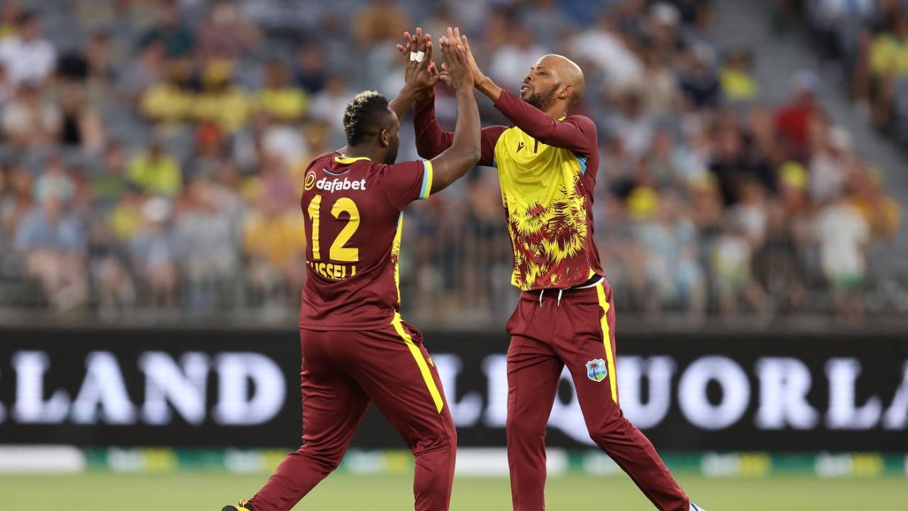 Roston Chase and Andre Russell celebrate a wicket