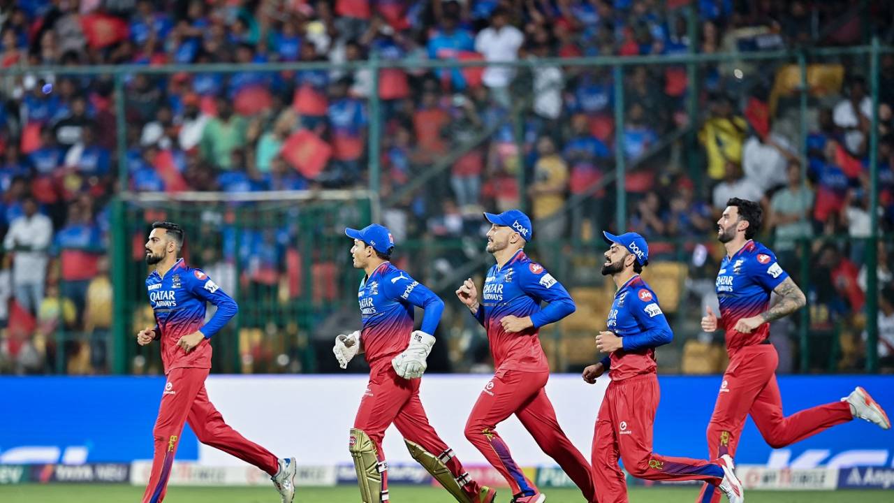 Royal Challengers Bangalore players march on to the field 