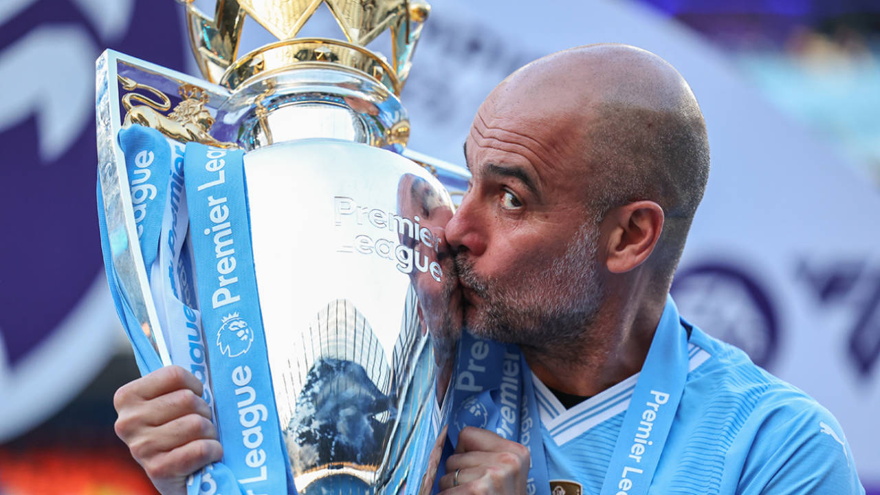 Manchester City manager Pep Guardiola kisses the Premier League trophy, May 19, 2024