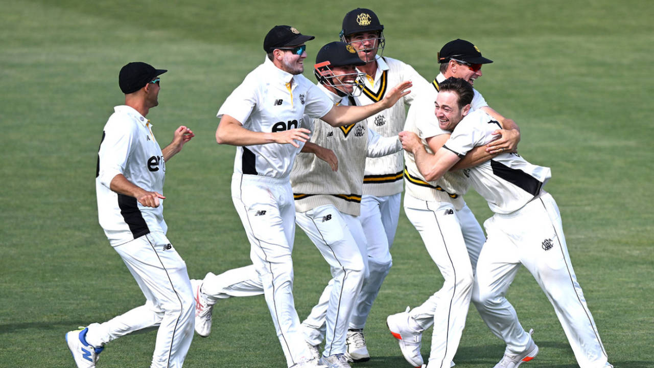 Brody Couch is mobbed by his team-mates after claiming a hat-trick, Tasmania vs Western Australia, Sheffield Shield, Hobart, November 4, 2024