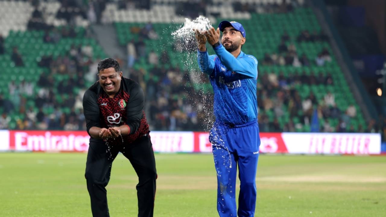 Hashmatullah Shahidi scoops up water off the outfield, Afghanistan vs Australia, Champions Trophy, Lahore, February 28, 2025
