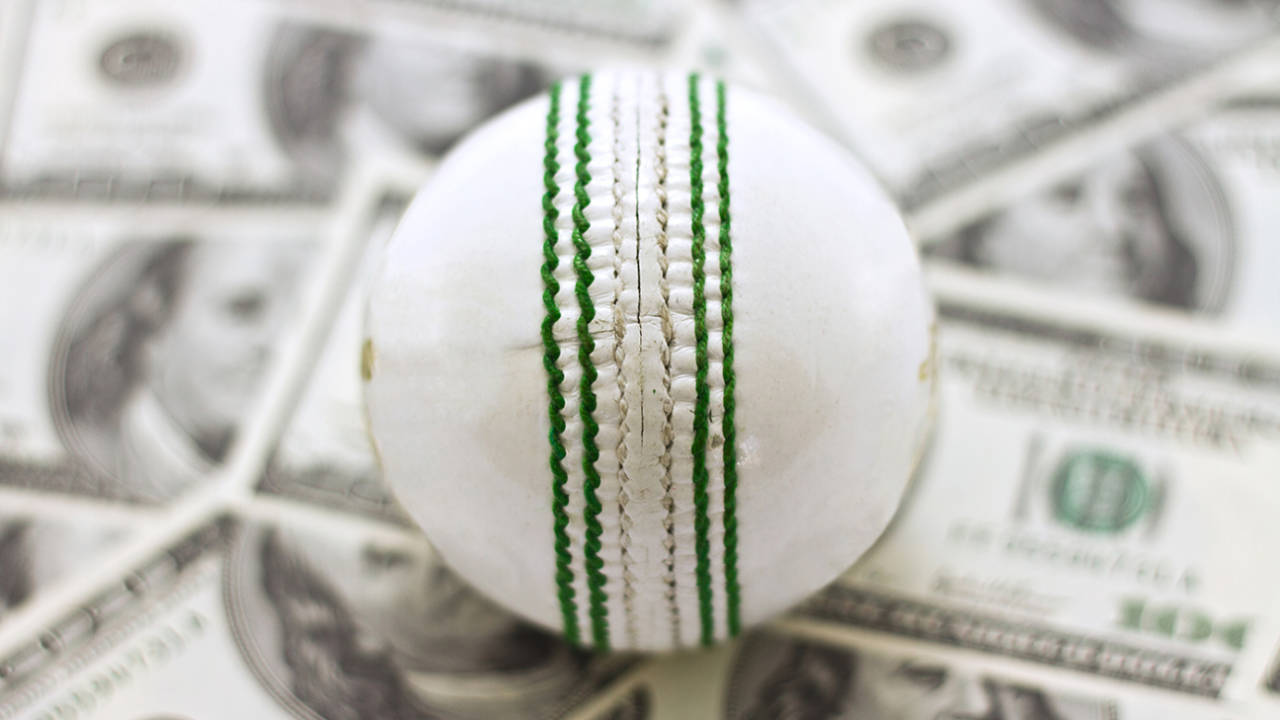 A stock image of a white cricket ball and money in the form of banknotes, symbolising corruption