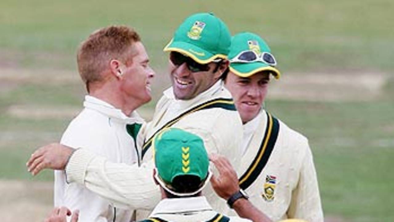 Shaun Pollock is congratulated by Justin Kemp after dismissing Clint Heron 