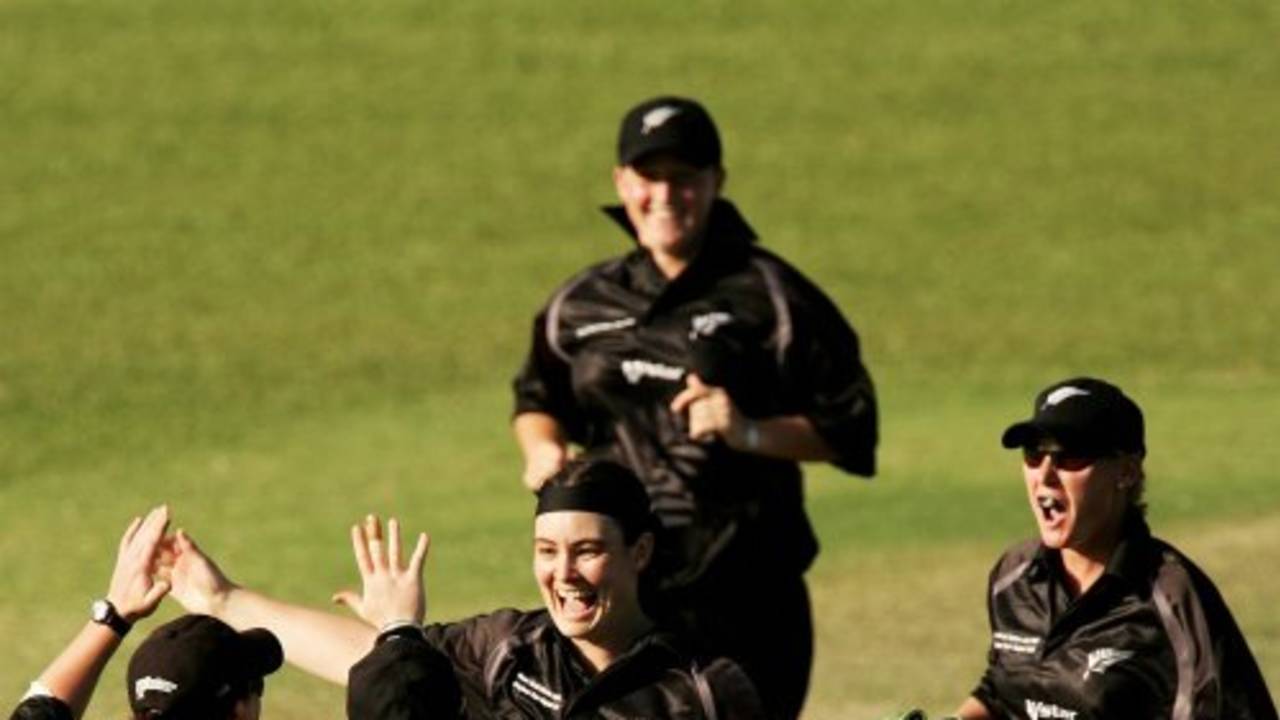 Sarah Tsukigawa is congratulated by her team-mates after picking up a wicket