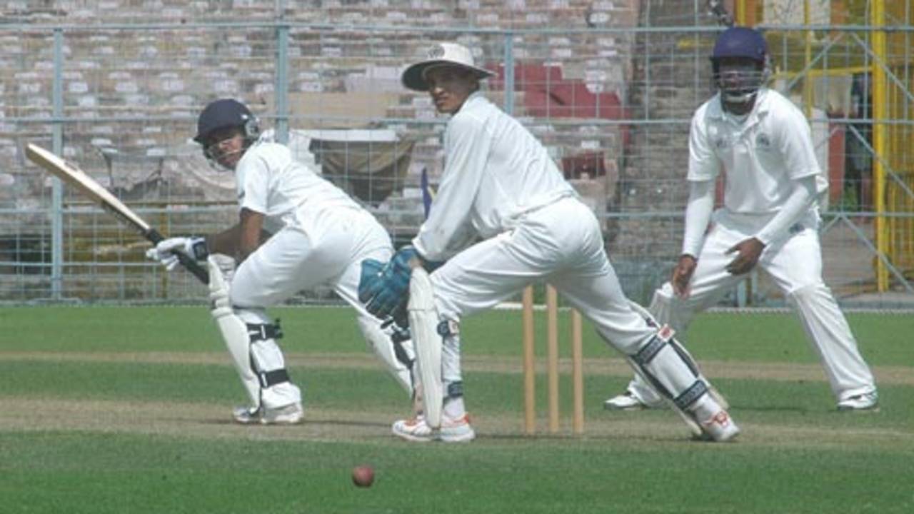 Manoj Tiwary plays one down the leg side while wicketkeeper Habeeb Ahmed looks on 