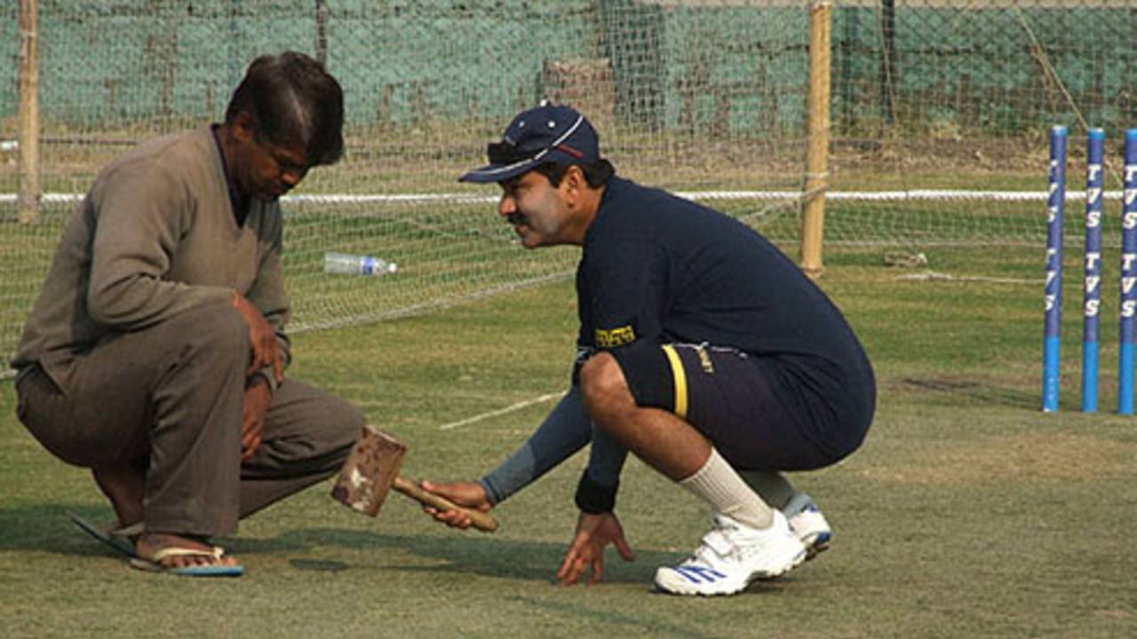 Delhi's bowling coach Manoj Prabhakar scrutinises the pitch