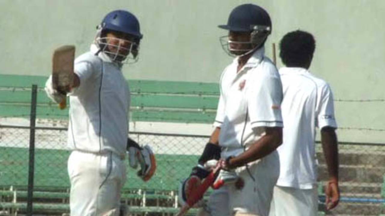 Rakesh Solanki raises the bat after his fifty